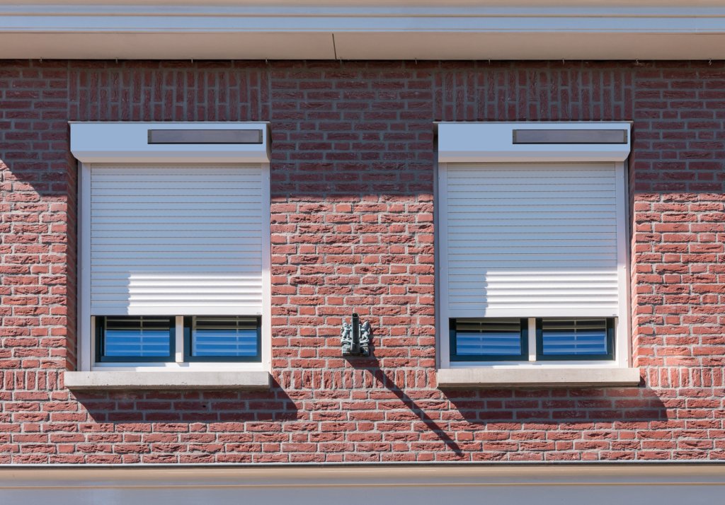 Solar rolluiken voor uw woning in Sittard-Geleen én Limburg. Witte solar rolluiken op een modern bakstenen gevel in Sittard-Geleen Limburg.